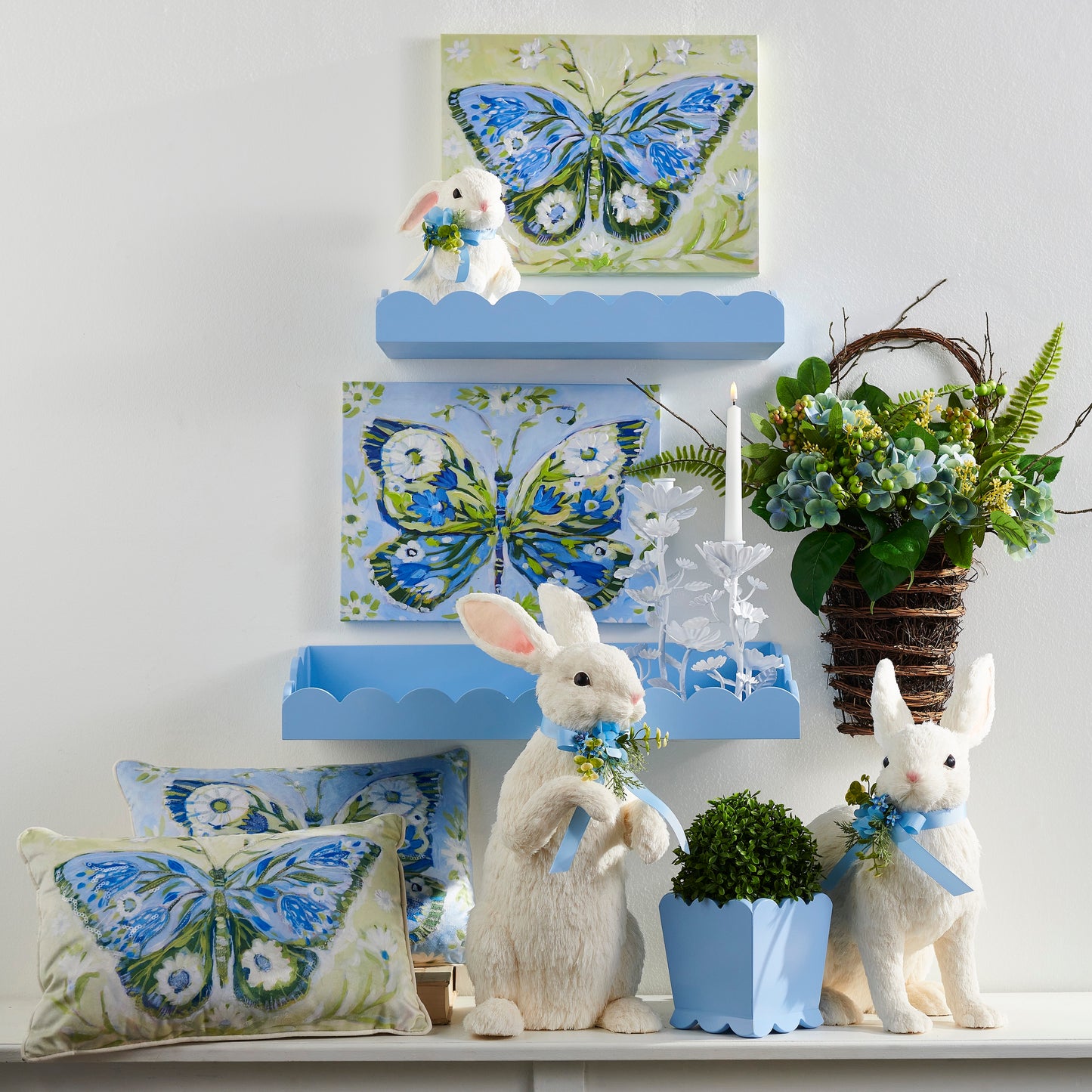 Decorative wall with blue shelves, rabbit figurines, butterfly-themed pillows, and plants.