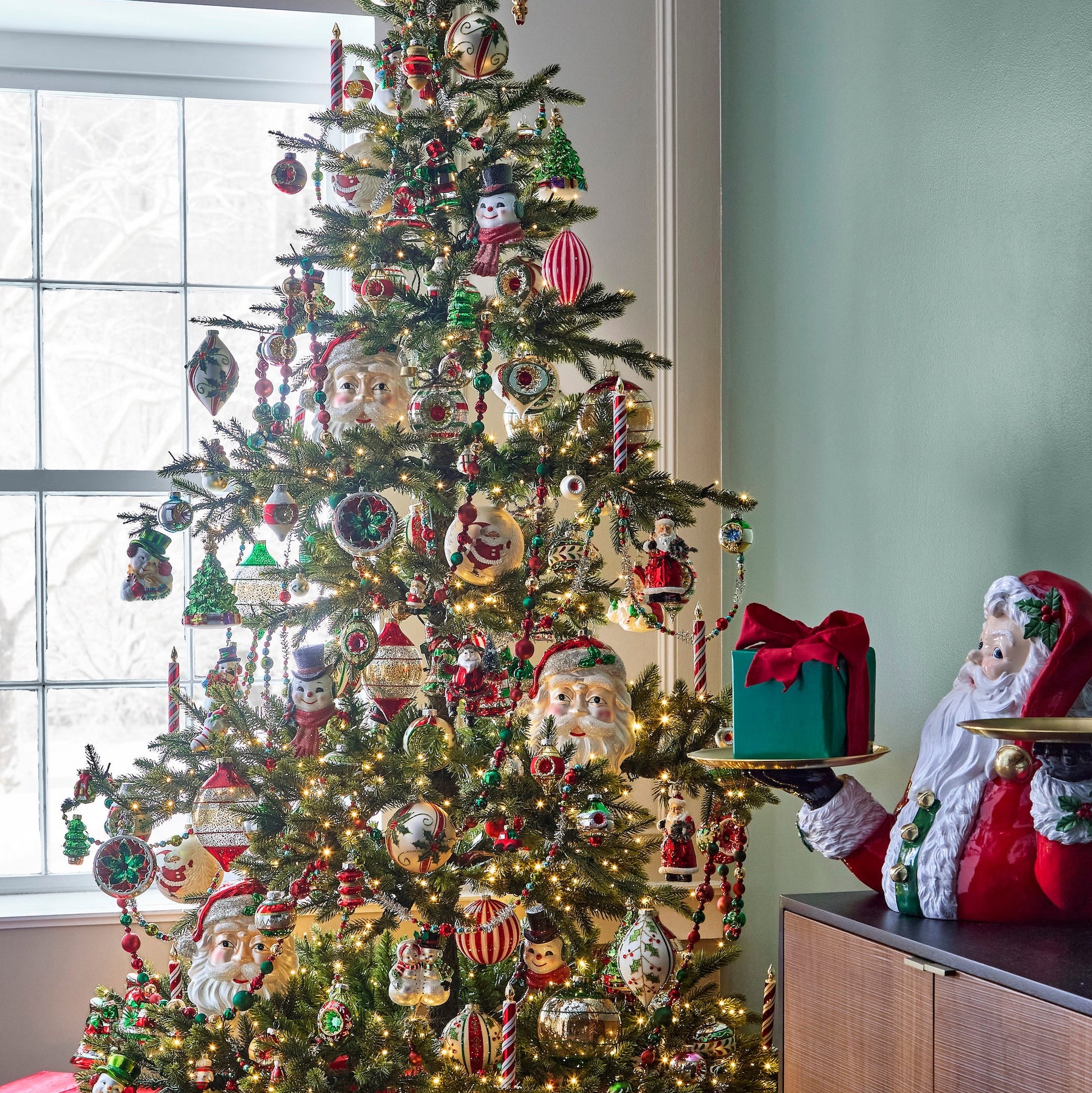 A set of four red and white striped peppermint clip-on candle ornaments on a Christmas tree.