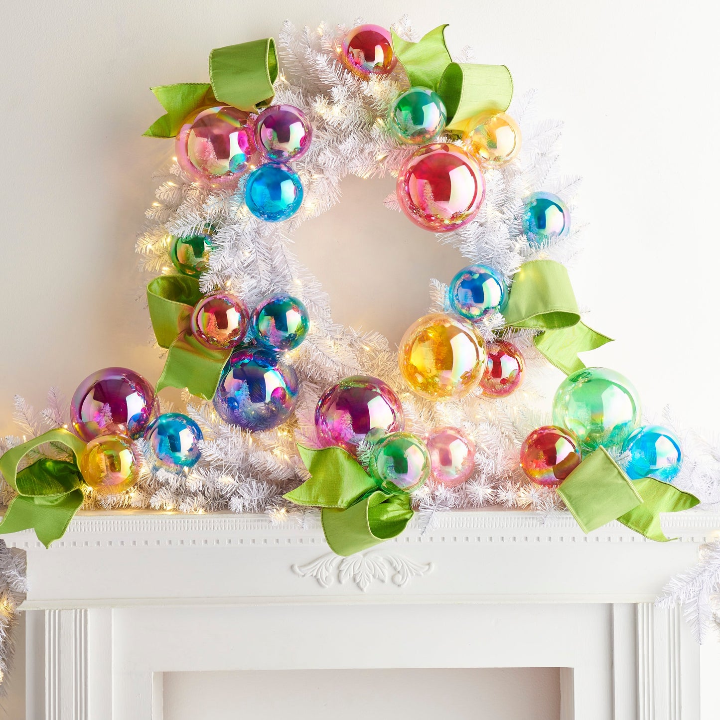Decorative wreath with colorful ornaments and green ribbons on a white surface.