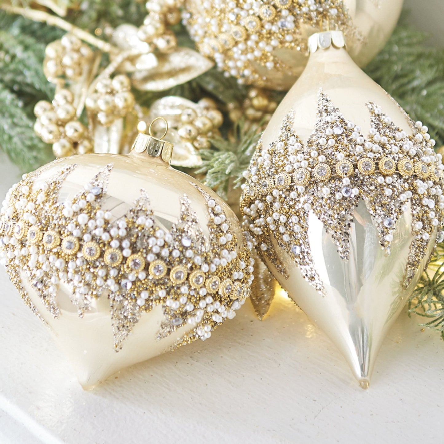 Decorative Christmas ornaments with gold and silver glitter on a green leaf background
