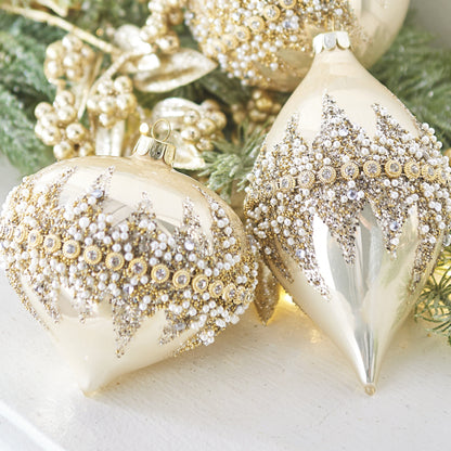 Decorative Christmas ornaments with gold and silver glitter on a green leaf background