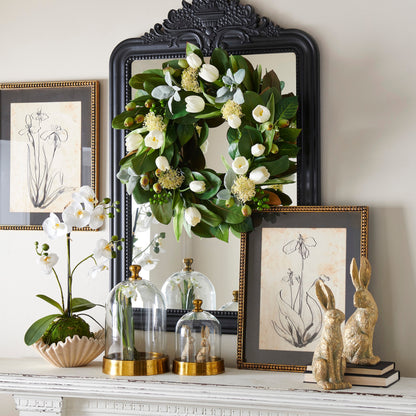 Decorative items including a wreath, plants, and framed art on a mantelpiece.