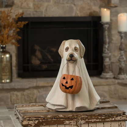 Decorative Halloween dog figurine in a ghost costume with a pumpkin basket in front of a stone fireplace.