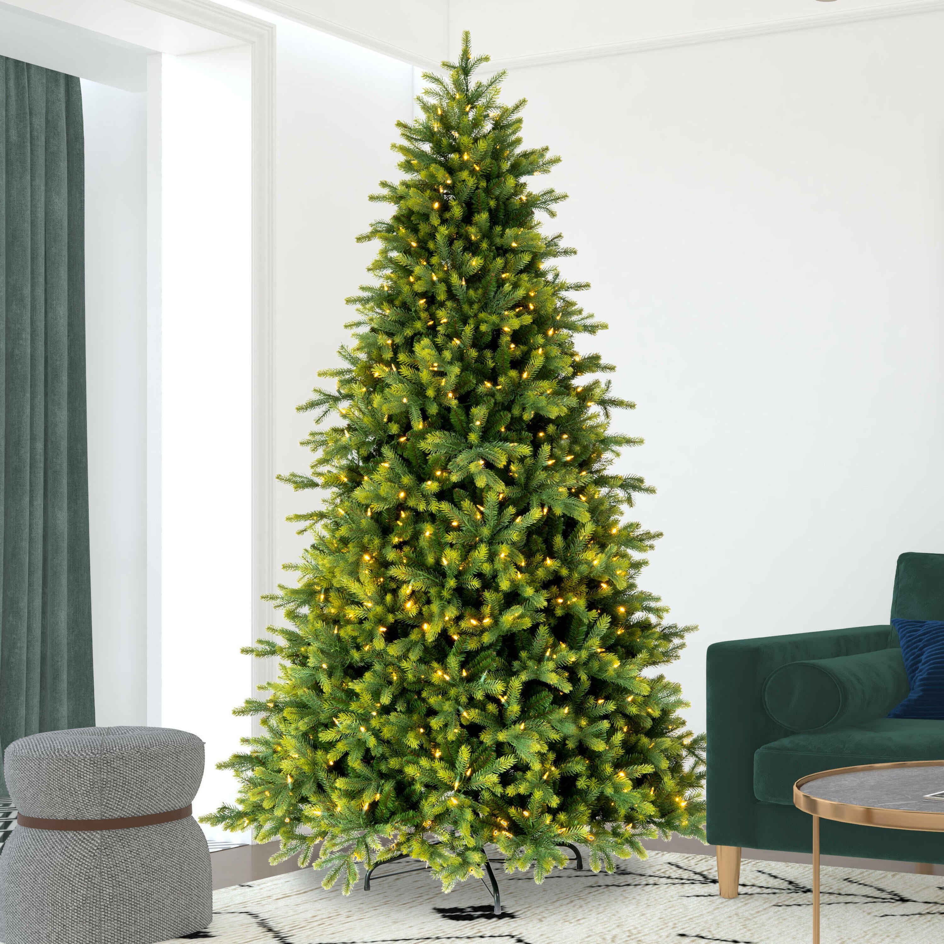 Decorated Christmas tree in a living room with a green sofa and gray ottoman.