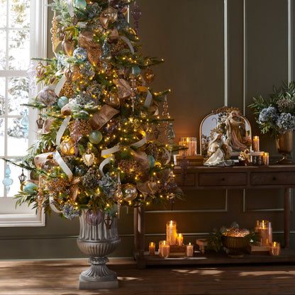 Decorated Christmas tree in a room with candles and a mirror.